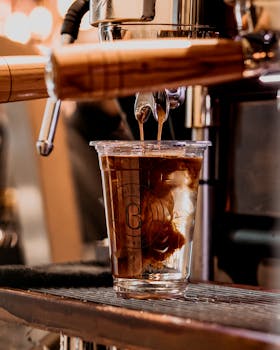 Rich espresso pouring into a glass cup in a Baku café, capturing coffee-making art.