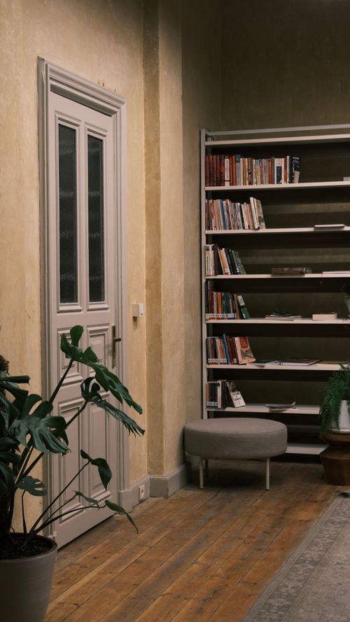 Free A cozy home interior featuring a bookshelf, door, and houseplant, perfect for reading and relaxation. Stock Photo