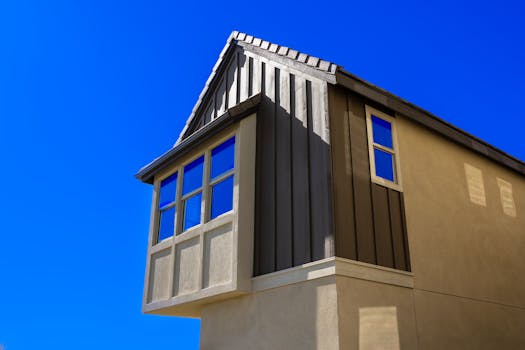 Low angle shot of a modern residential building facade against a clear blue sky.