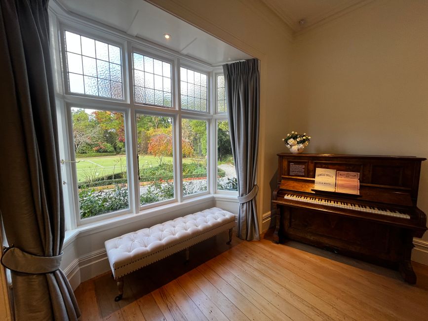 Photo by Relaxing Journeys on Pexels Sophisticated home interior featuring a piano and a scenic garden view through large windows.