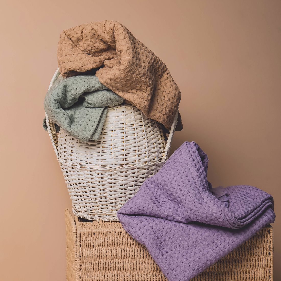 Freshly folded towels displayed over wicker baskets in a guest bathroom