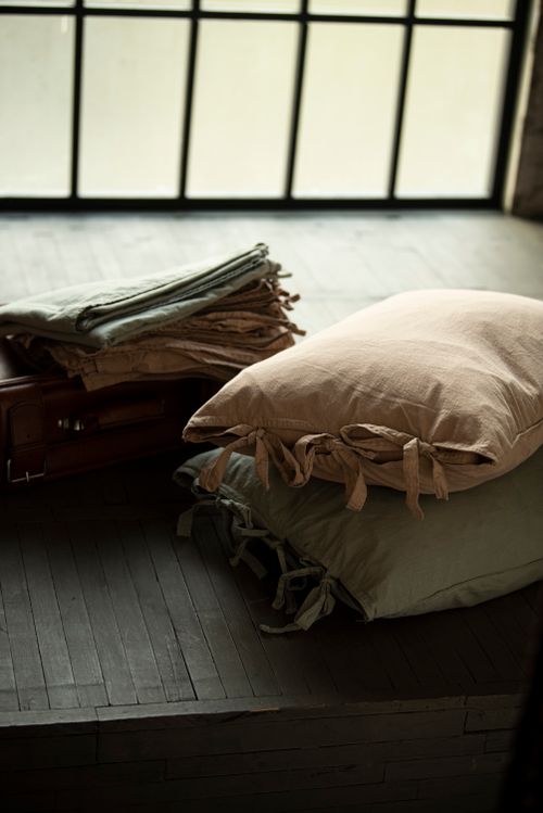 Free Warm, inviting cushions on a wooden floor with natural light through a large window. Stock Photo