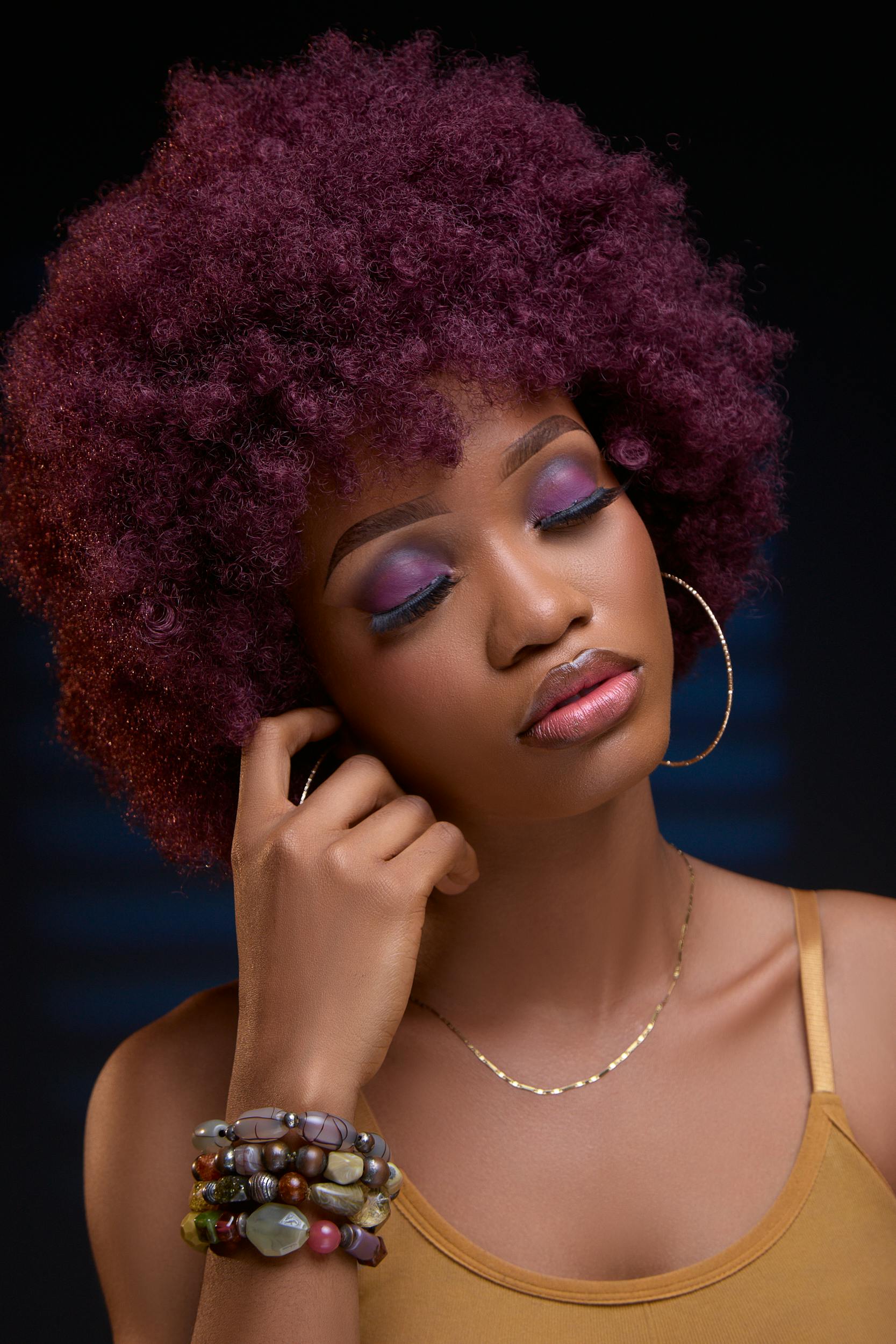 一位留着卷发、闭着眼睛、戴着环形耳环的女人的美丽肖像