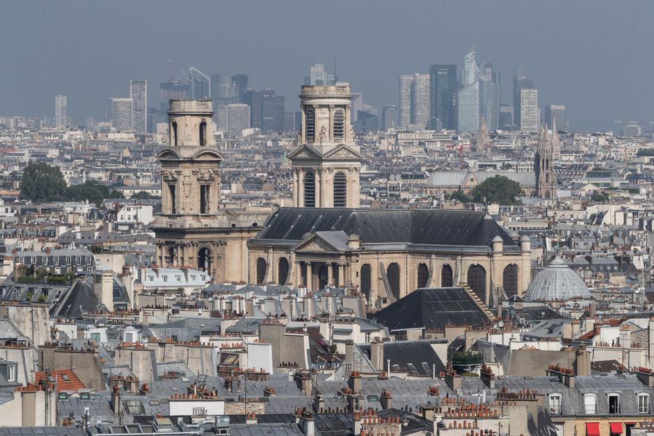 Une vue panoramique de Paris avec l'église Saint-Sulpice en arrière-plan de gratte-ciels modernes.
