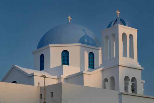 Stunning view of a classic white and blue domed church in Folegandros, Greece.