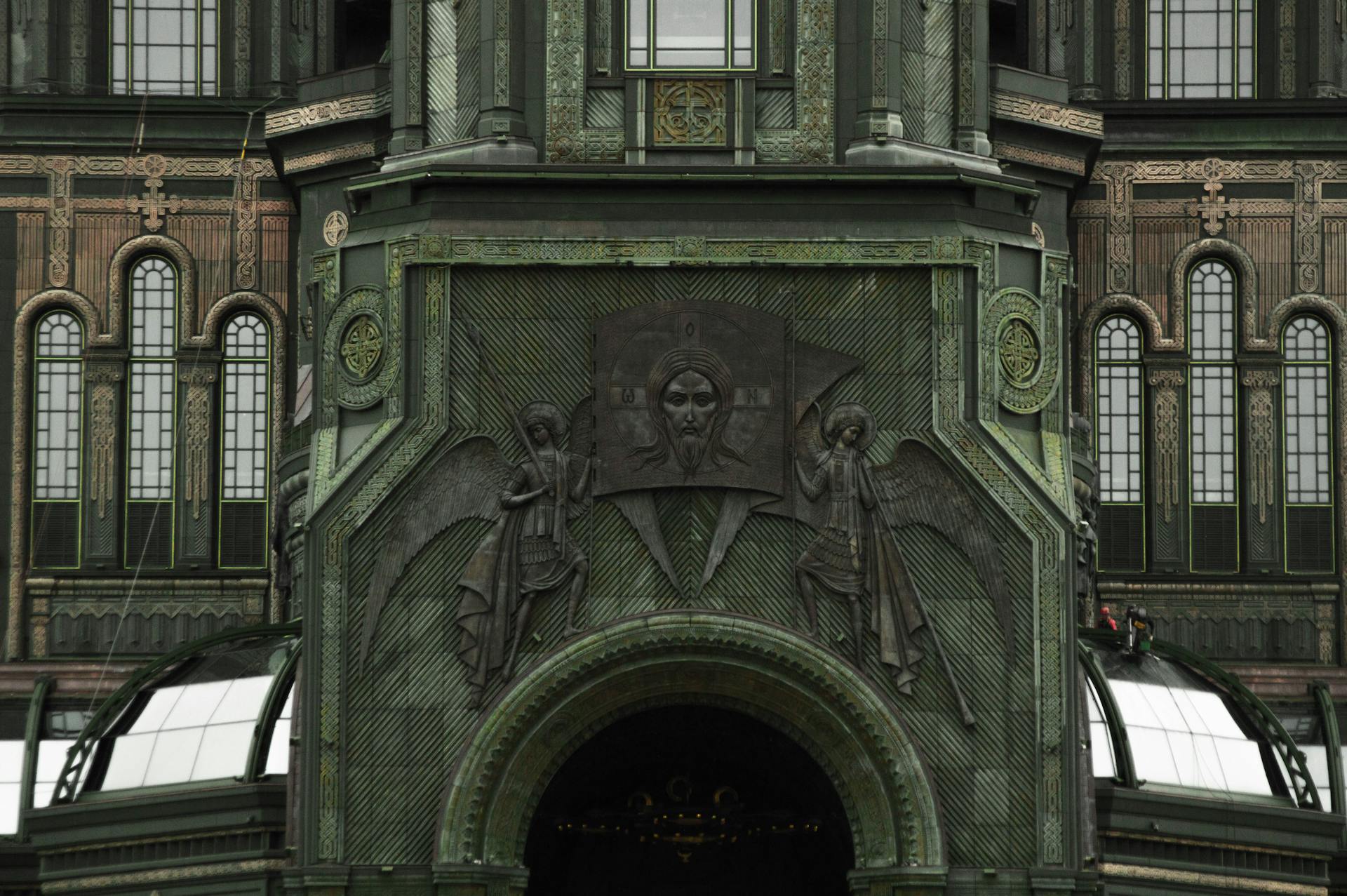 Detailed view of a building facade with intricate architectural relief and religious symbols.