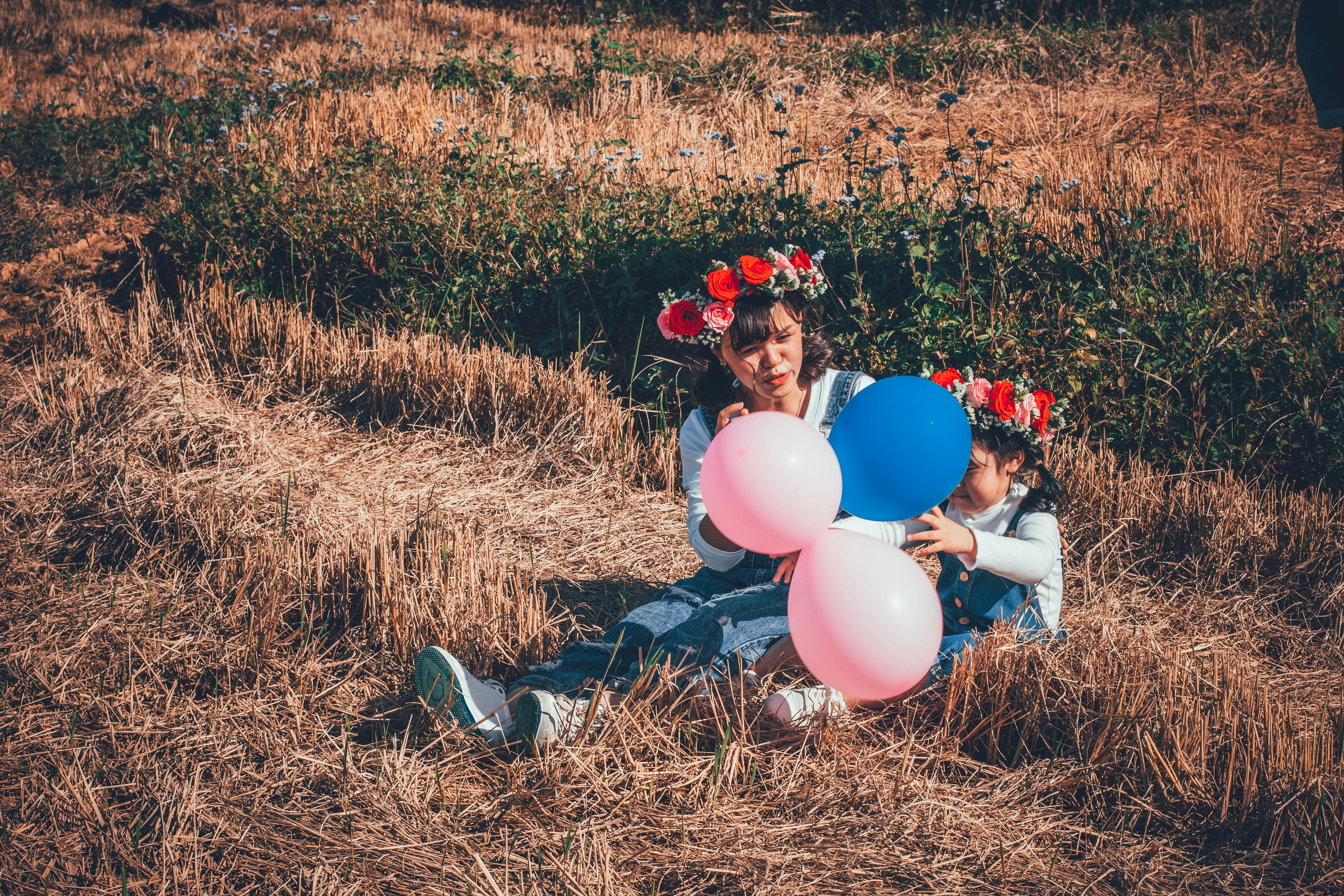Woman Holding Pink and Blue Balloons
