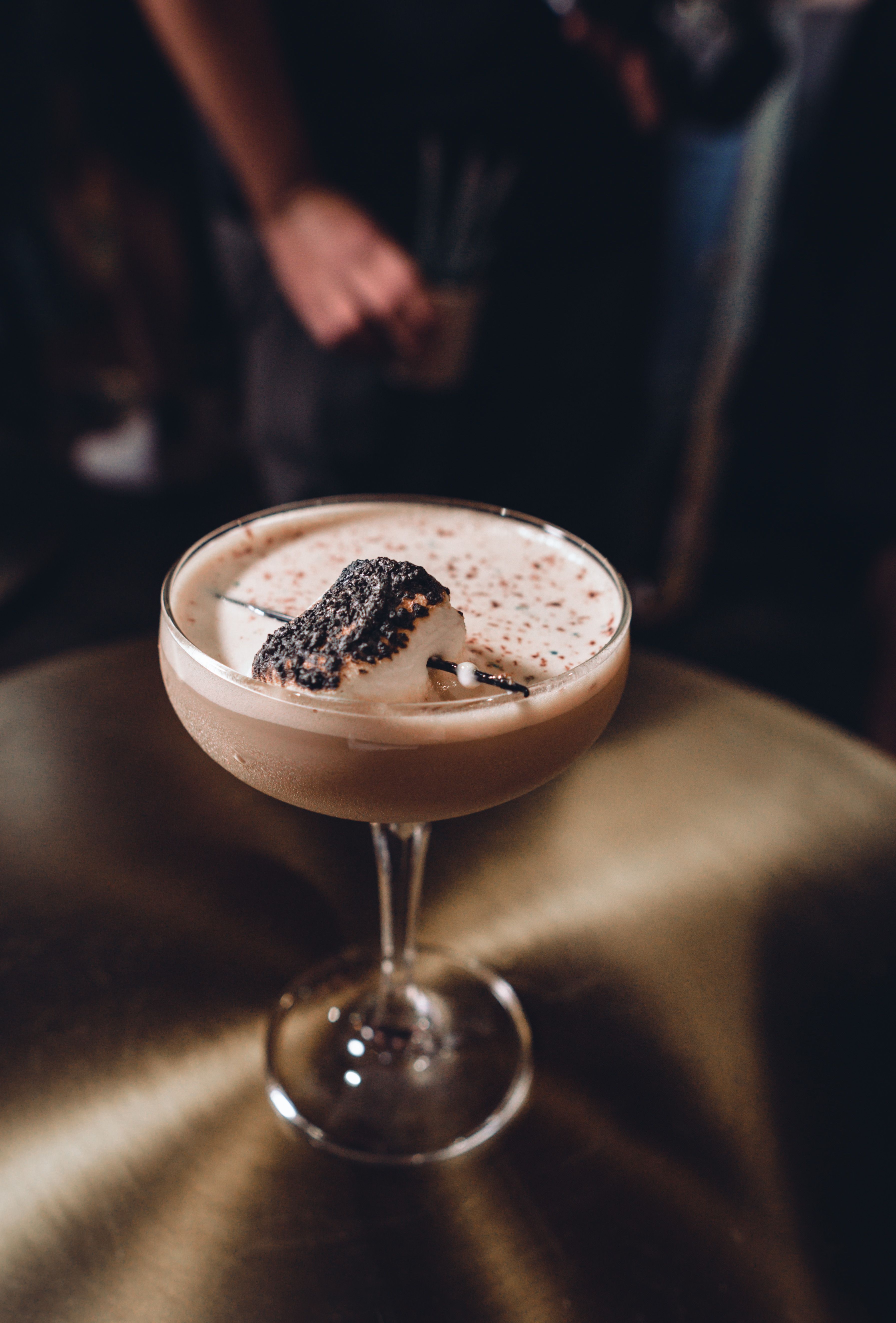 A luxurious chocolate cocktail topped with whipped cream served in an elegant glass.