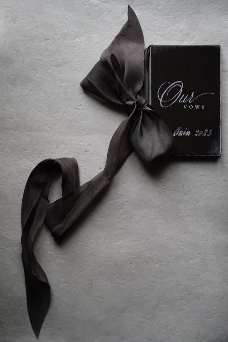 A Booklet With Wedding Vows And A Ribbon 