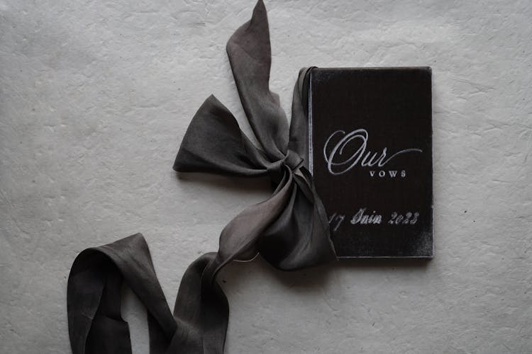 A Booklet With Wedding Vows And A Ribbon 