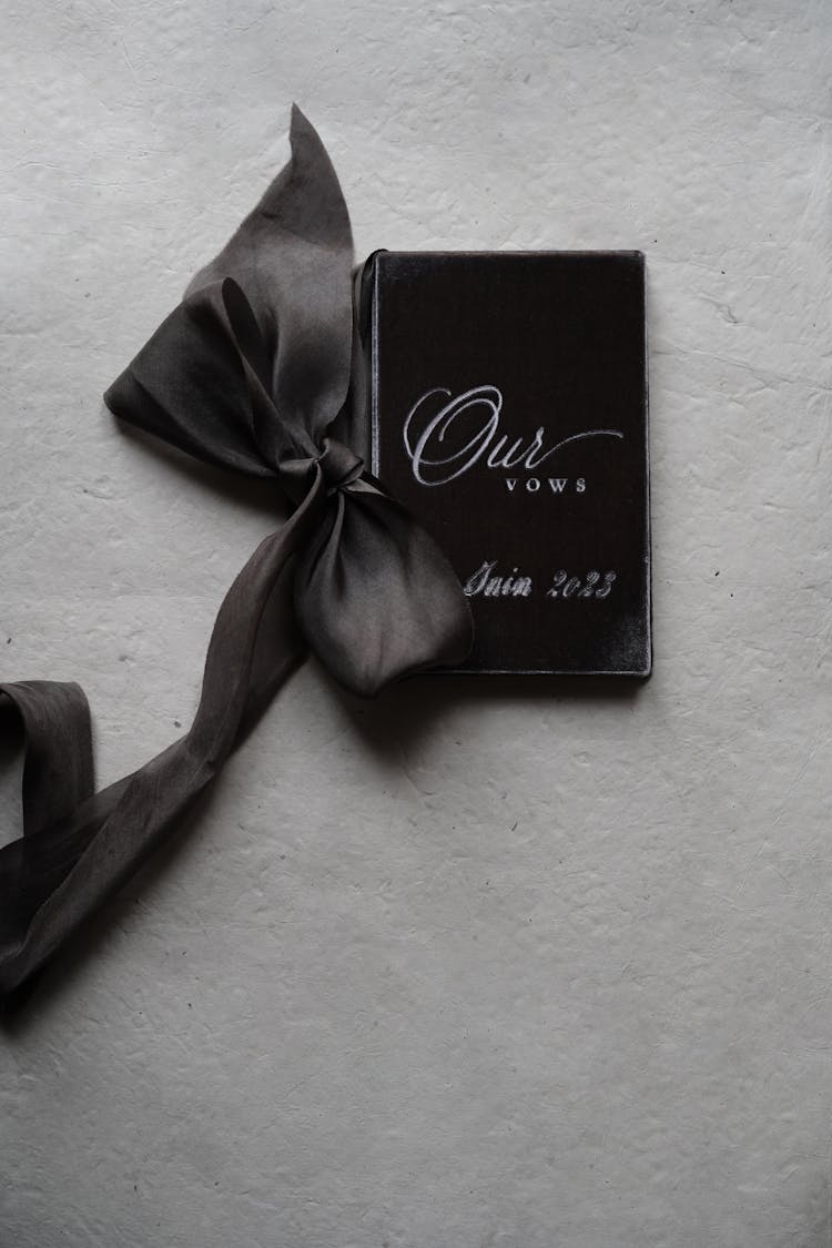 A Booklet With Wedding Vows And A Ribbon 