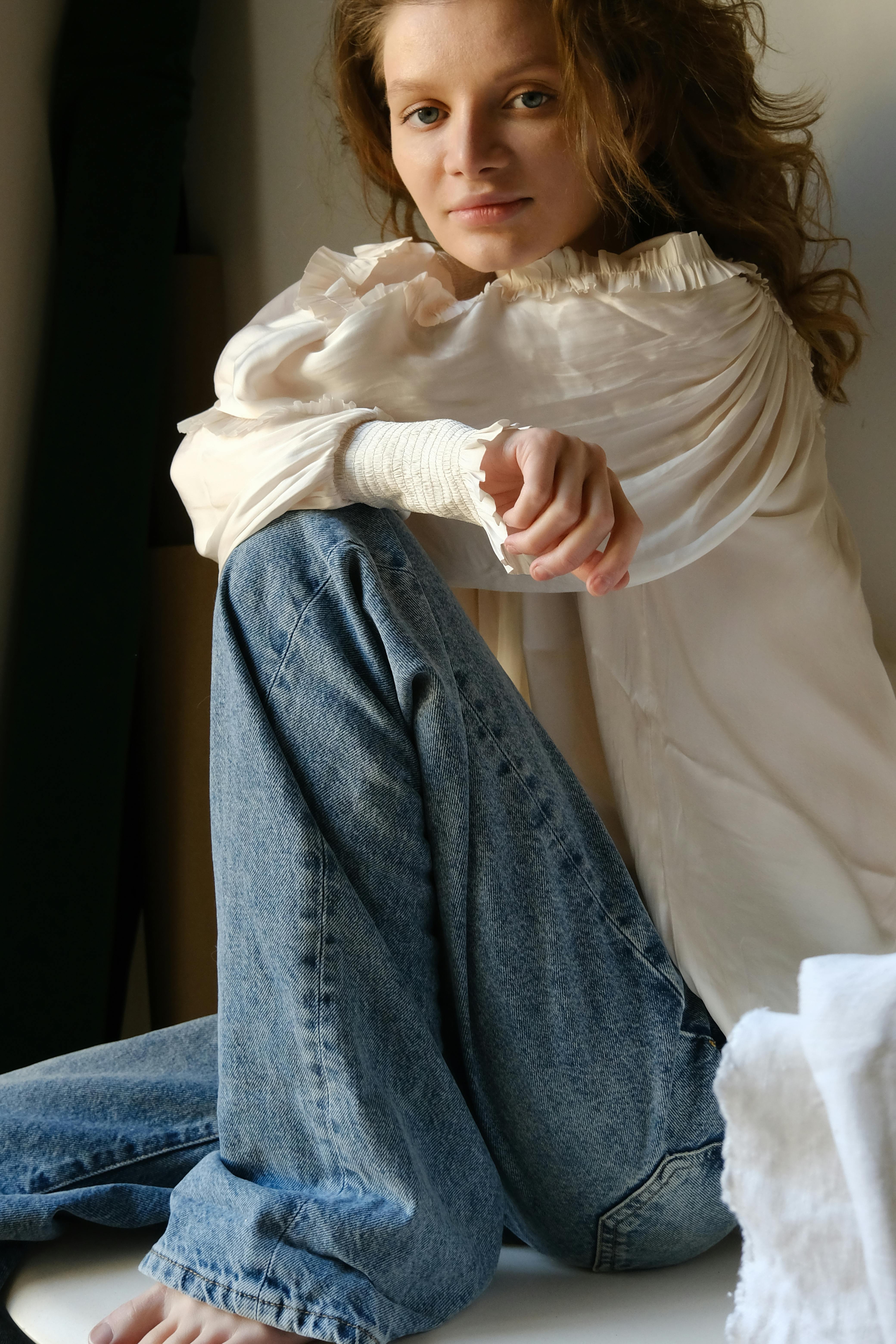 Young woman in a casual outfit posing indoors with natural light.