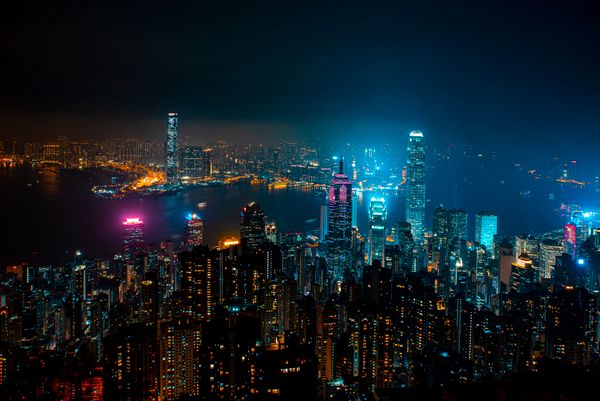 Uma vista noturna vibrante do horizonte iluminado de Hong Kong refletindo modernidade urbana e beleza arquitetônica.