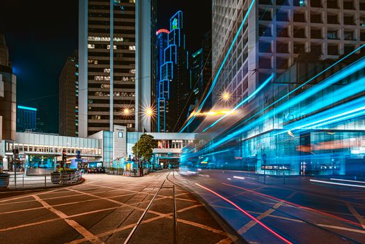 Dynamic urban scene capturing vibrant light trails against a modern city skyline at night.