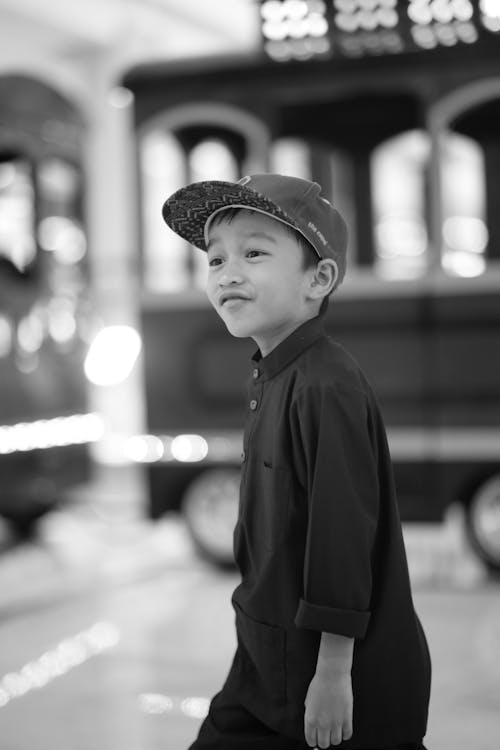 Black and White Photo of a Smiling Boy in a Cap