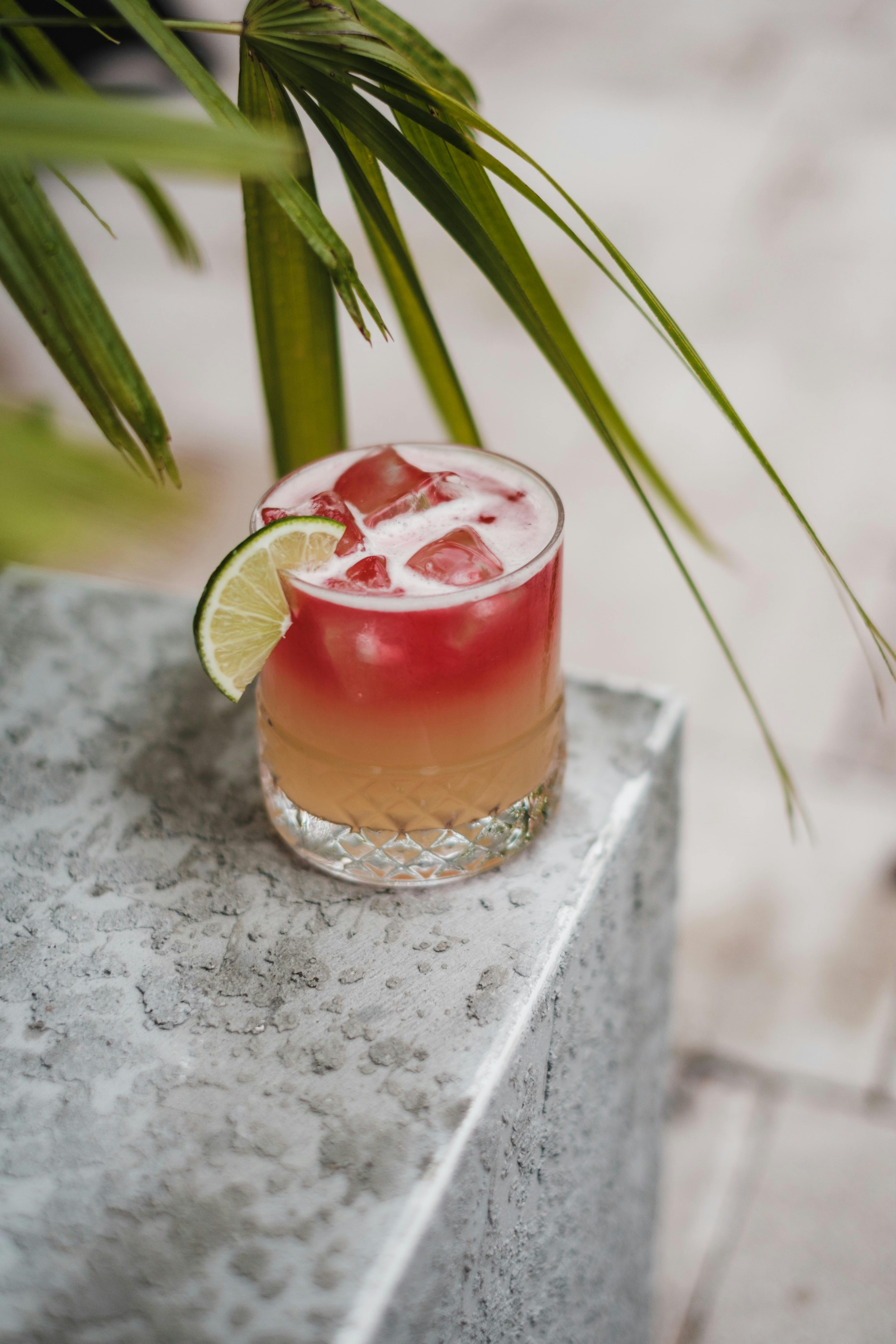 cold cocktail in glass with lime slice