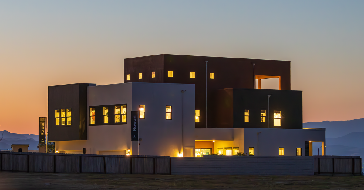 Contemporary architecture glowing at twilight, showcasing sleek design and illuminated windows.