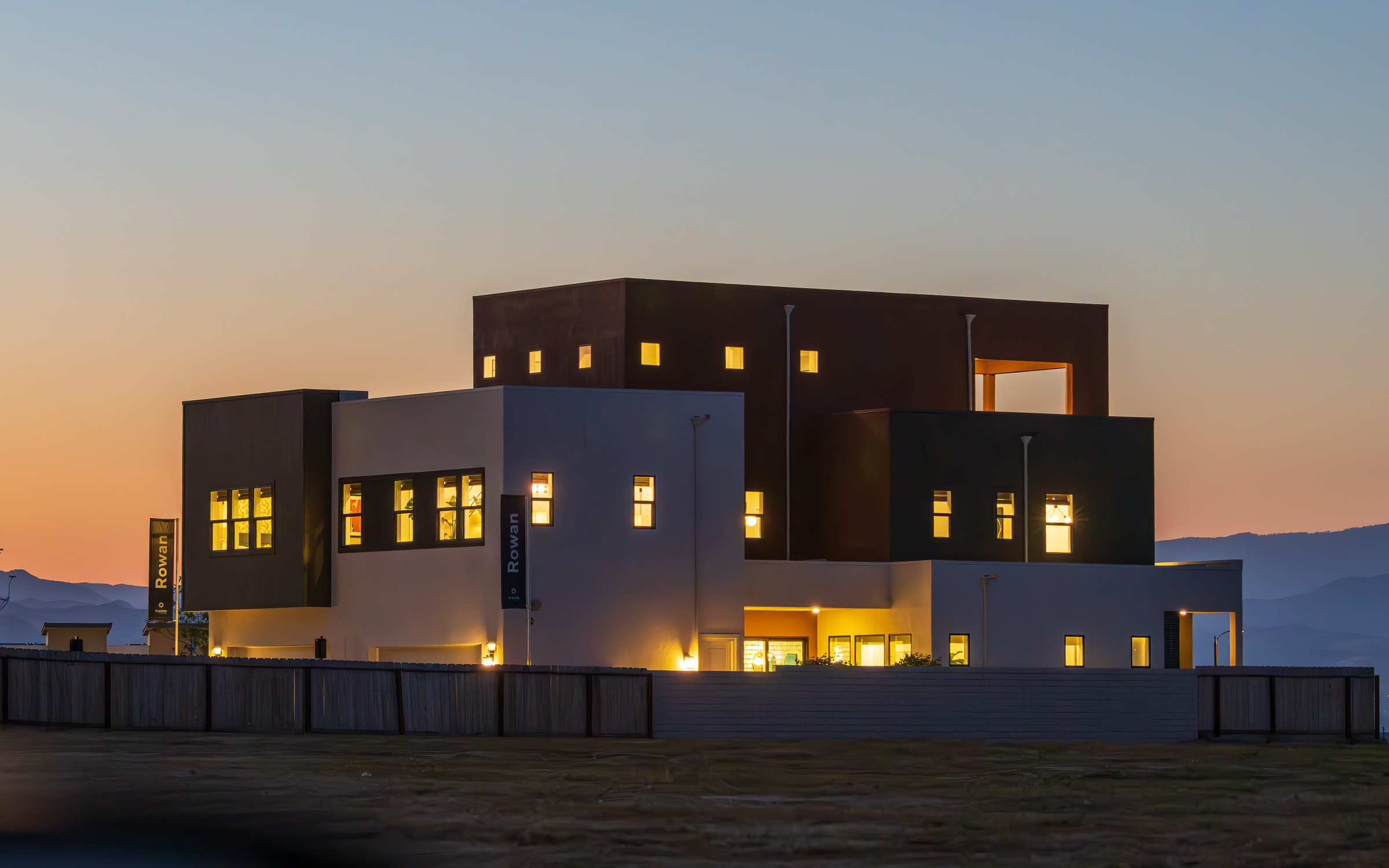 Artist's impression: modern low-rise luxury apartment building near the water at dusk.