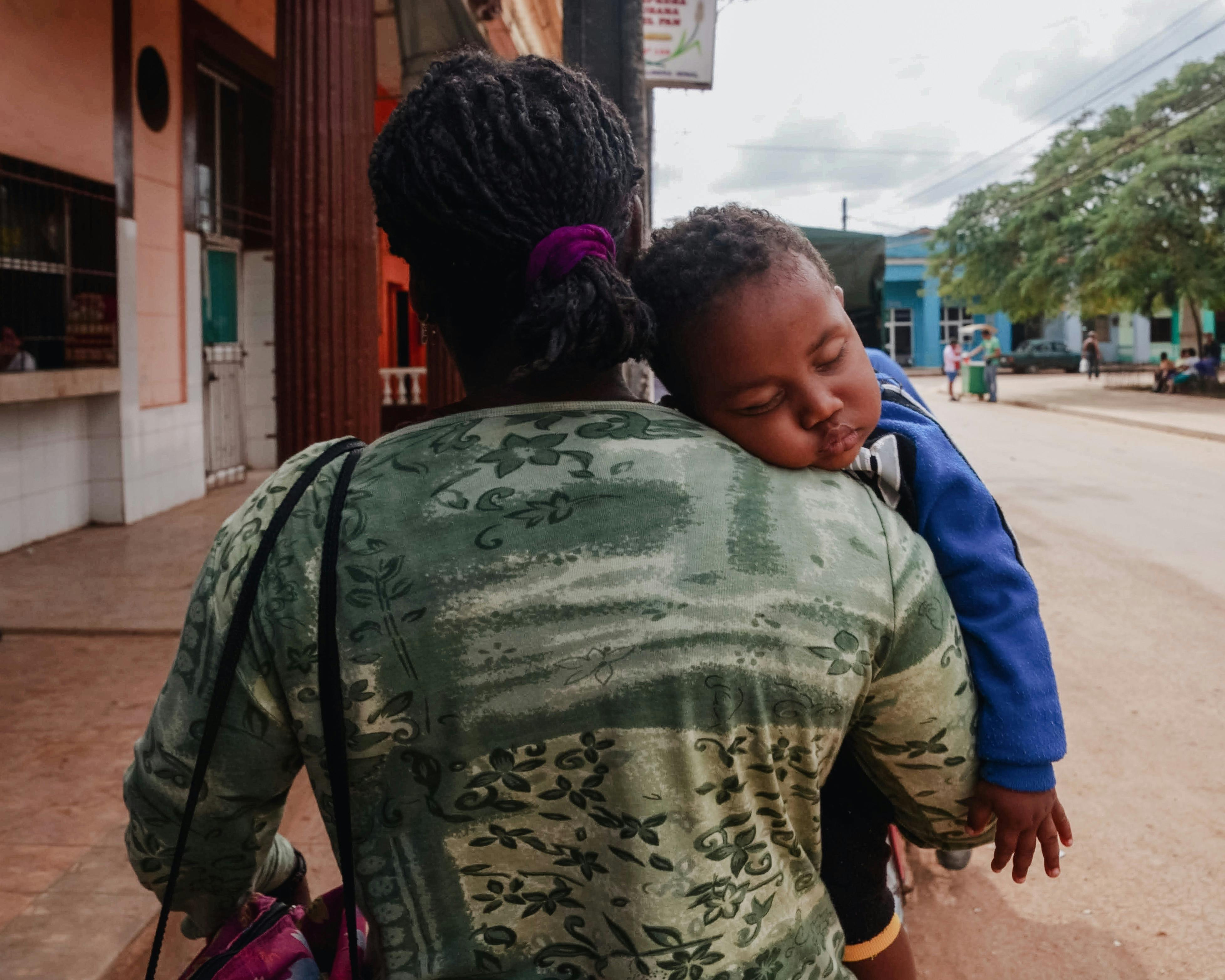 photo of a mother carrying a sleeping baby