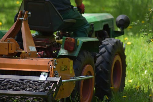 Man on Lawnmower in Field