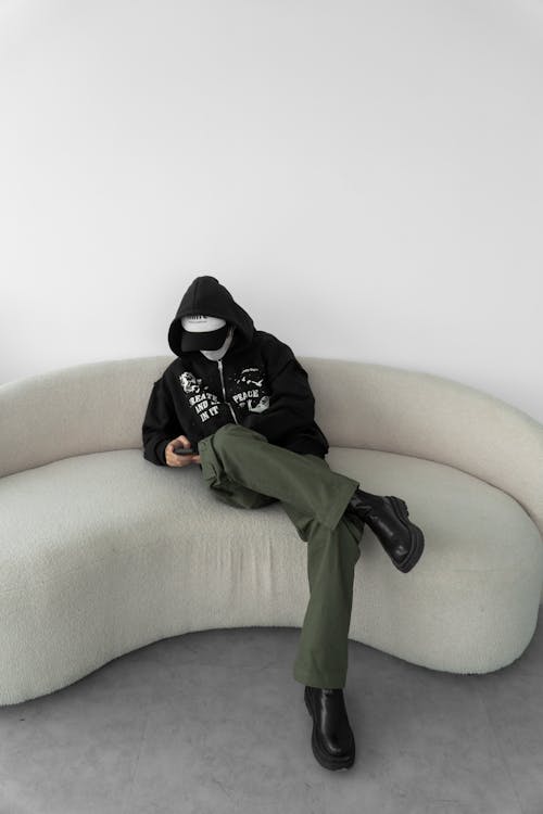 Young Person in a Trendy Outfit Sitting on a Couch 