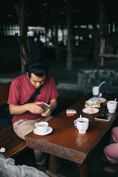 一名穿着休闲装的男子在舒适的咖啡桌旁享用咖啡和零食