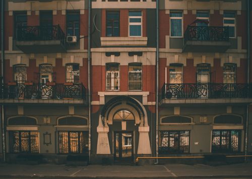 Free Vintage urban building facade showcasing detailed architecture and ornate balconies at sunset. Stock Photo