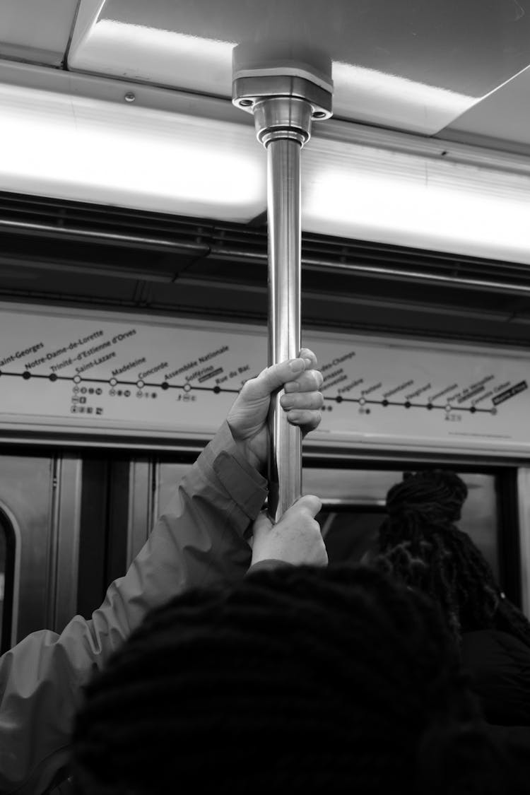 Person Holding Onto A Pole In A Subway 