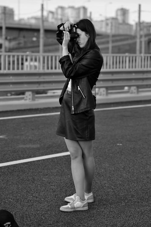 Free A female photographer captures urban street scenes in black and white. Stock Photo