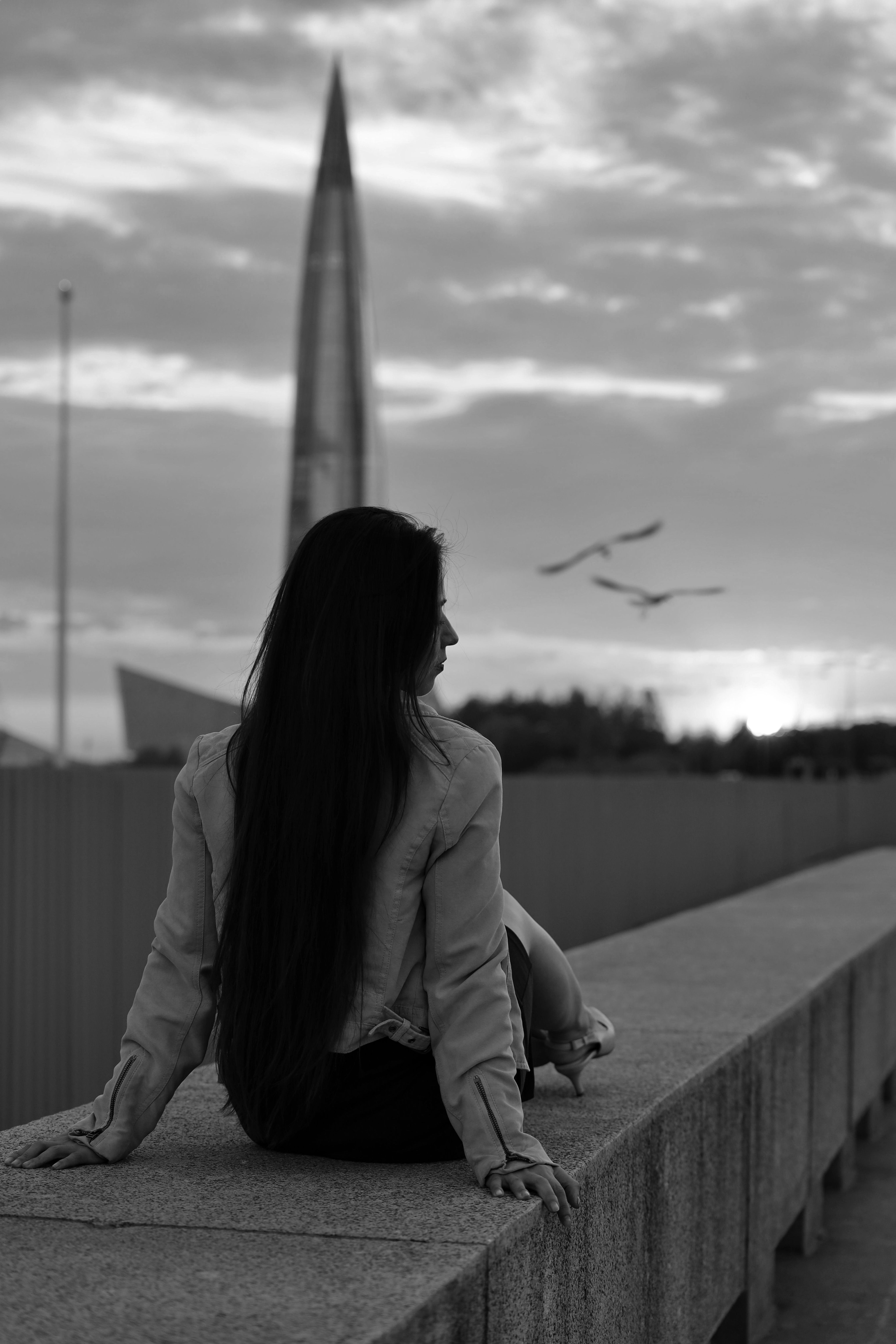 Woman Sitting on a Low Concrete Wall · Free Stock Photo