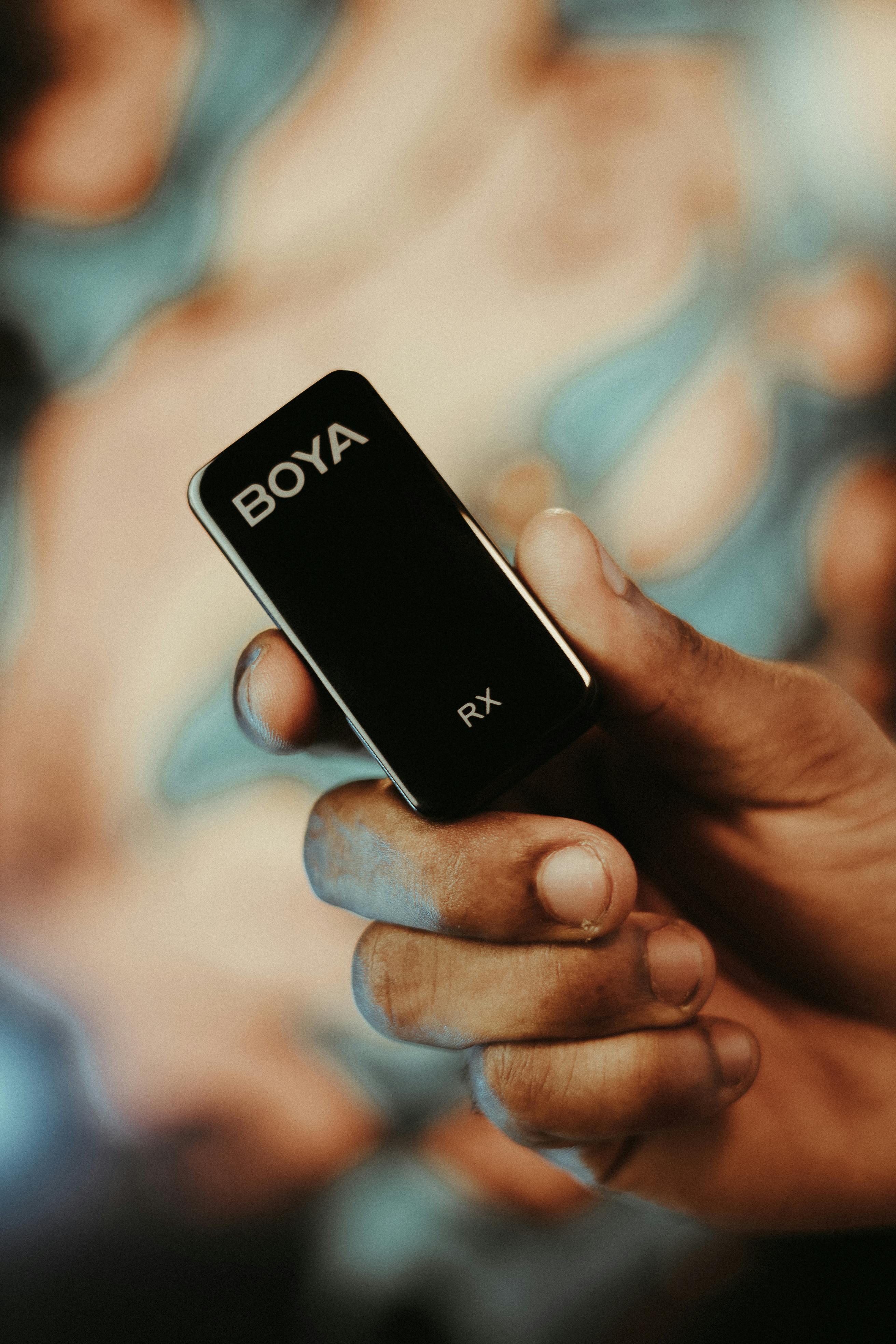 a person holding a black device with the word bova on it