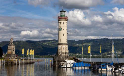 Free The iconic Lindau Lighthouse and lion statue at the harbor of Lake Constance on a cloudy day. Stock Photo