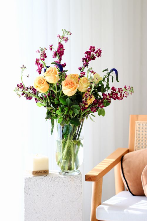 Free A graceful bouquet of roses and wildflowers in a vase, brightening a sunny room. Stock Photo