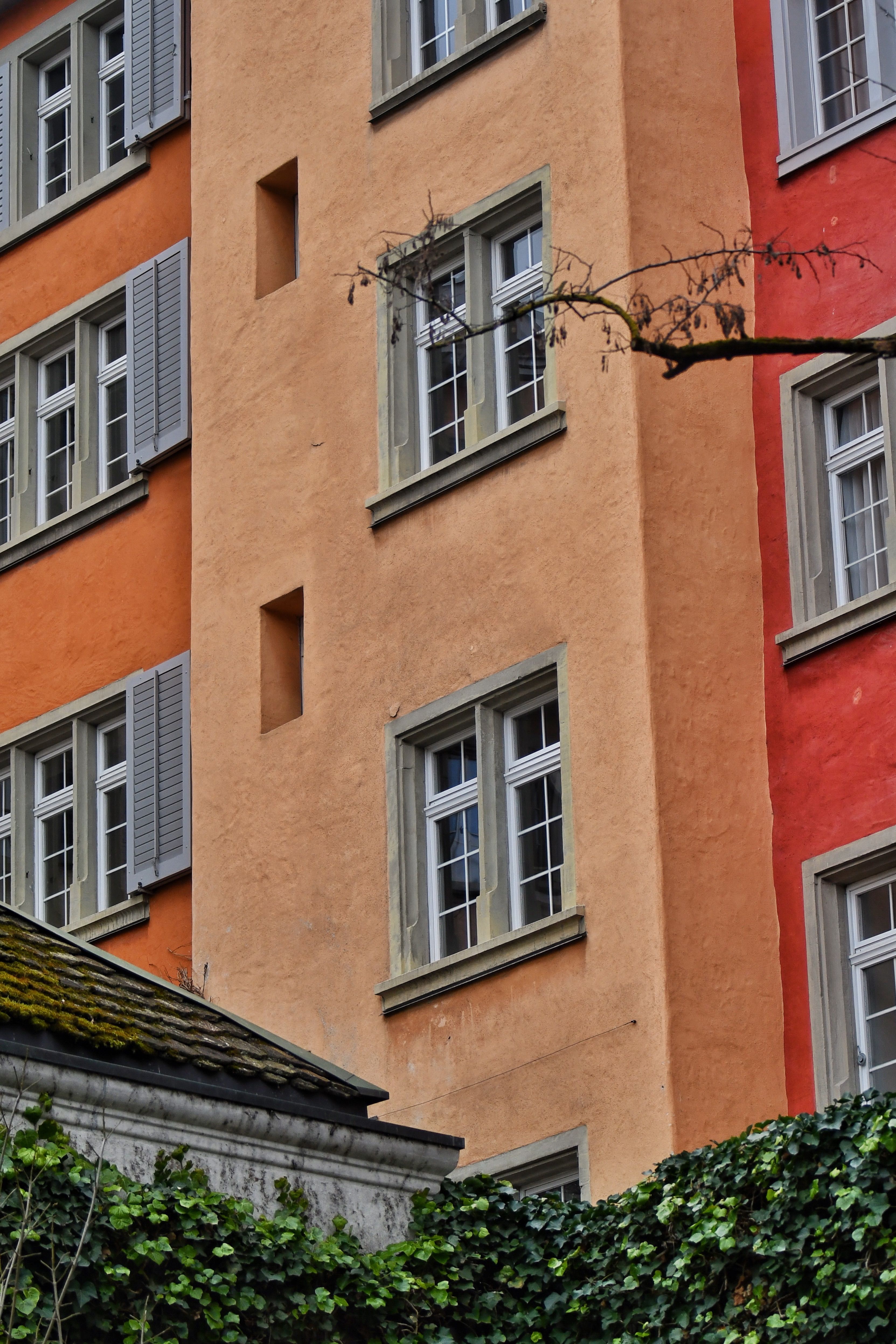 Free Vibrant red and orange facades of a residential building with classic windows Stock Photo