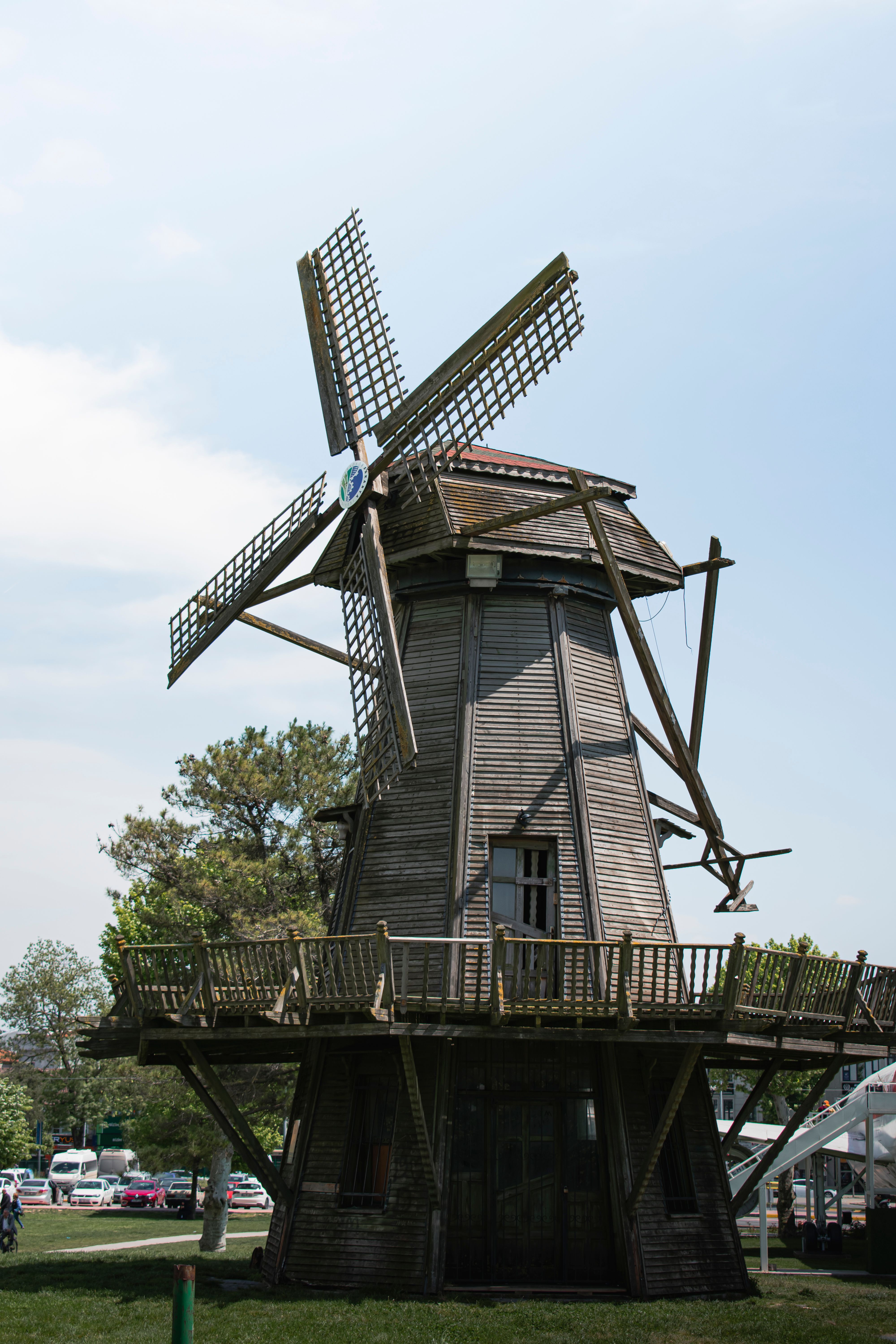 Rustic wooden windmill standing tall under a bright sky, perfect for travel and architecture enthusiasts.