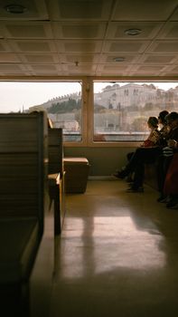 Interior view of a ferry in Istanbul with an exterior view of historic buildings.