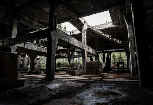 Dark and eerie abandoned industrial building with decaying concrete structure in Přebuz, Czechia.
