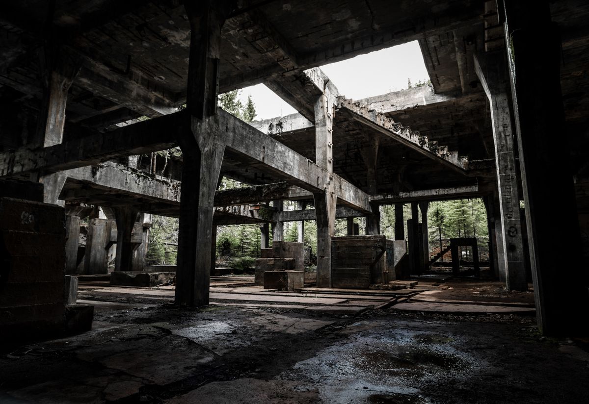 Interior of an abandoned concrete building with collapsing walls and broken windows, similar to what you can see from the visitor walkway on Hashima Island