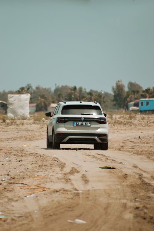 Back view of a Volkswagen T-Cross Driving on a Dirt Road 