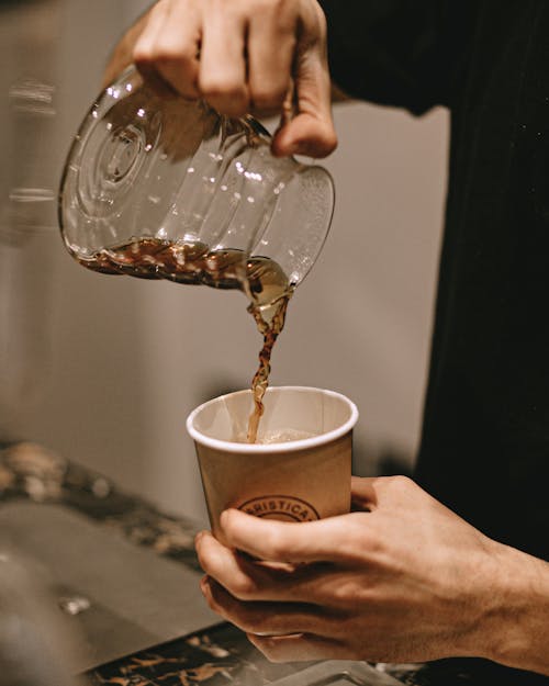 Man Pouring Filter Coffee in Takeaway Cup