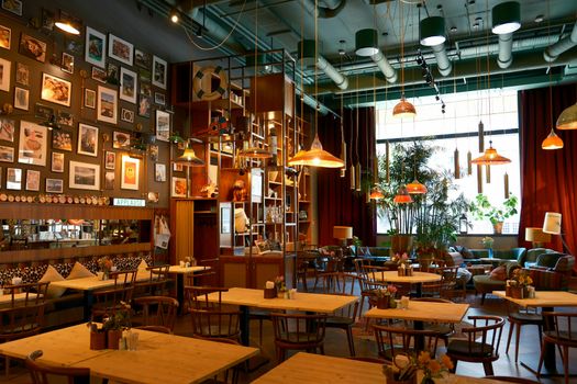 Charming café interior featuring wooden tables, eclectic wall art, and warm lighting for a relaxing ambience.