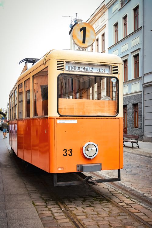 Free Classic orange tram in a city setting, showcasing urban public transportation charm. Stock Photo