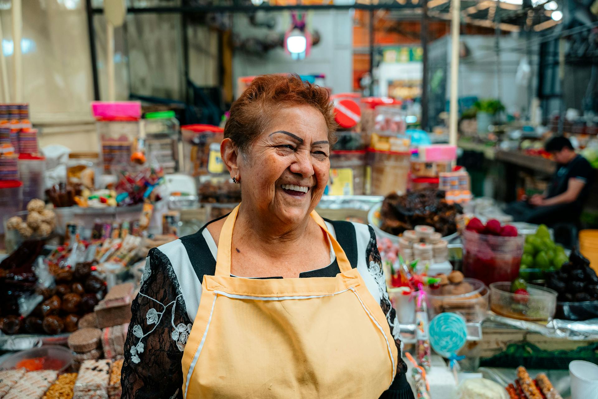 Smiling Old Woman in Apron Selling on Market