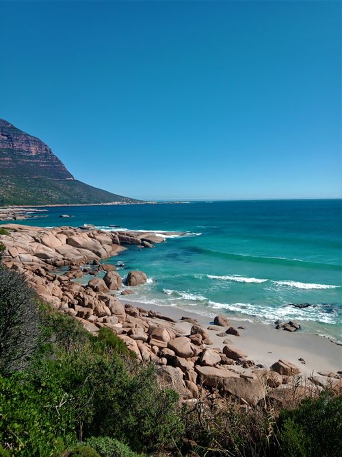 Free Discover a stunning rocky coastline with vibrant turquoise waters under a clear blue sky. Stock Photo