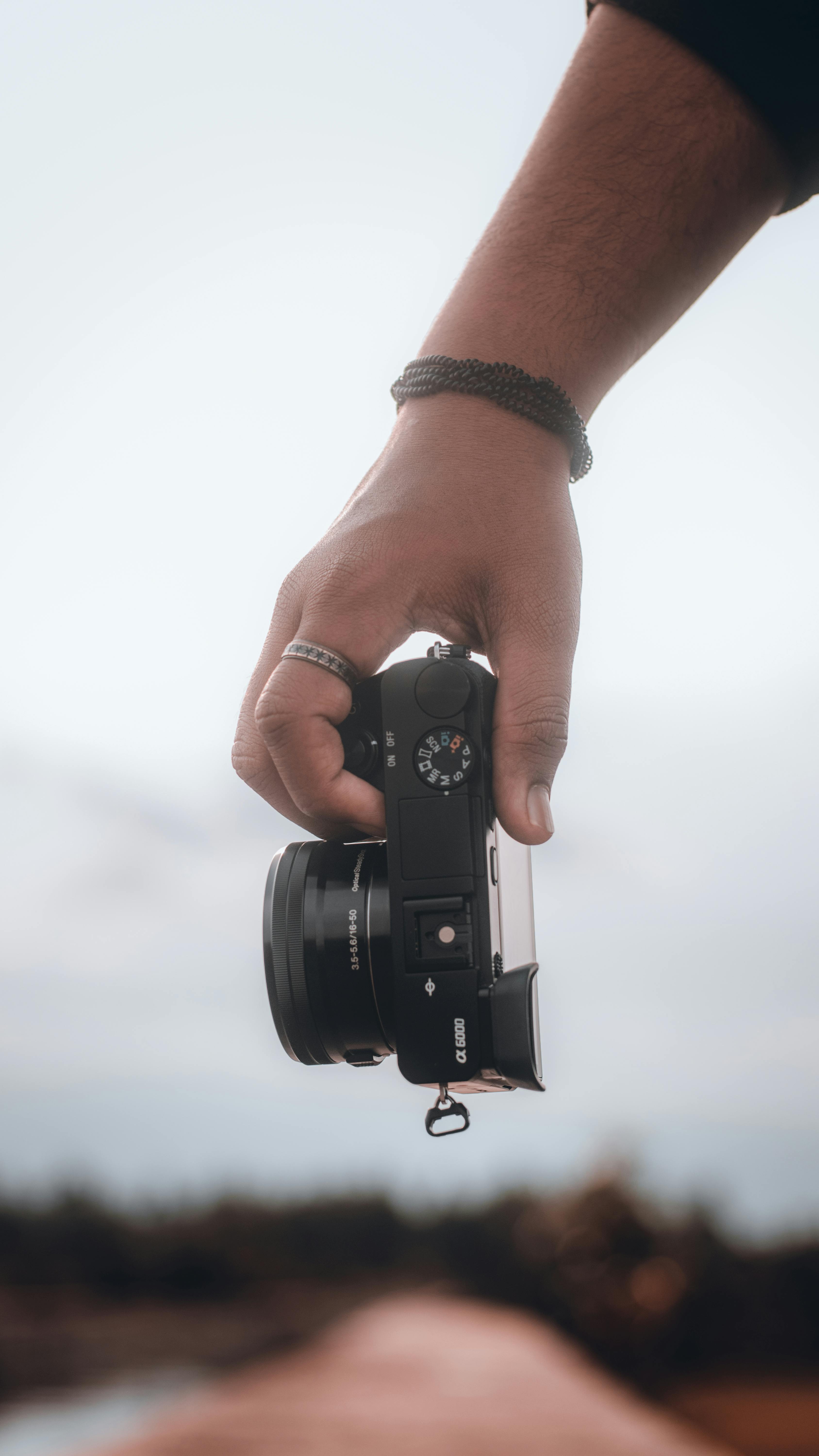 High Angle Photo of Person Sitting While Holding Black Camera · Free Stock  Photo