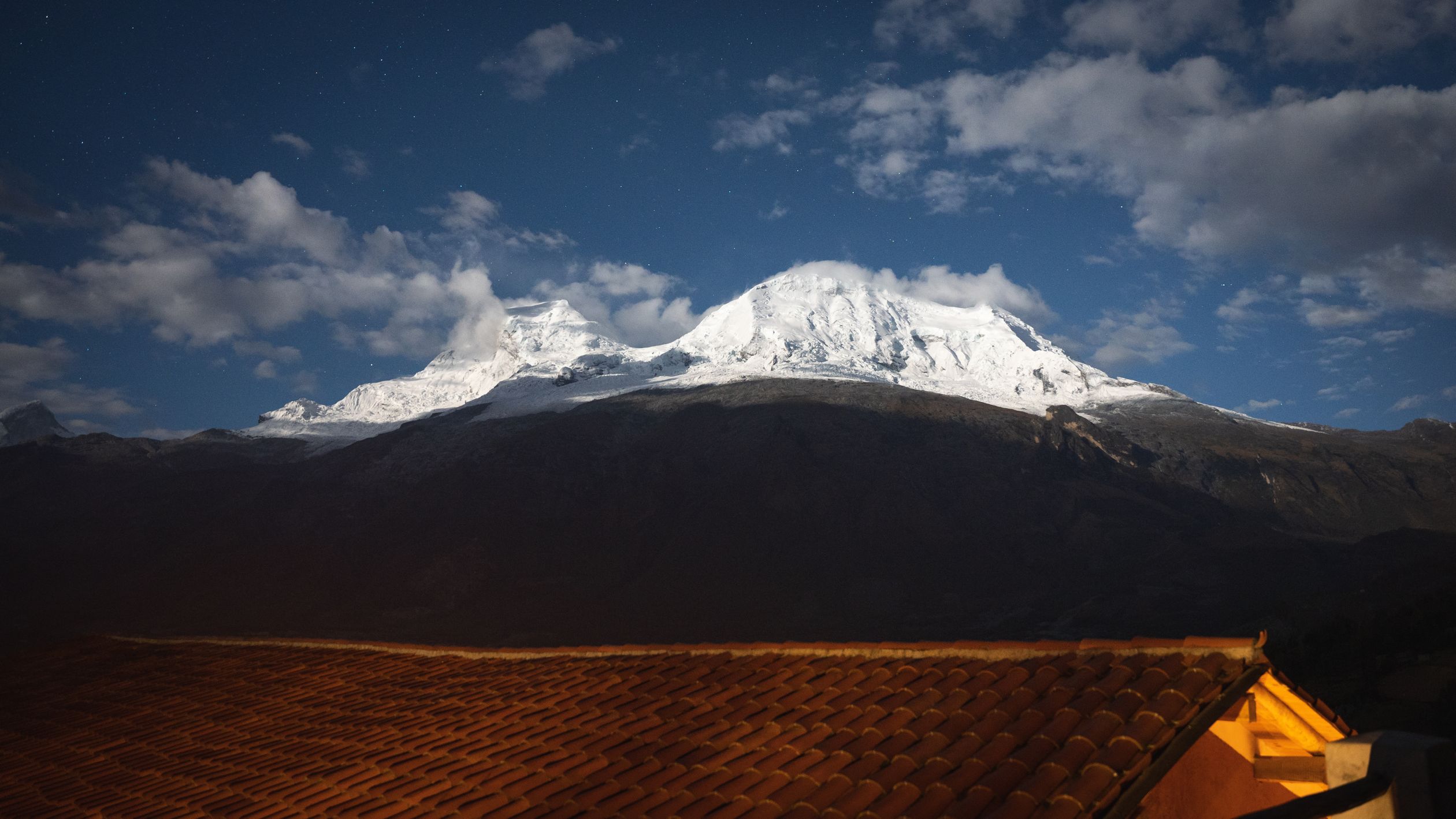 Stunning view of snowy peak from rooftop at night in Huaraz, Peru.