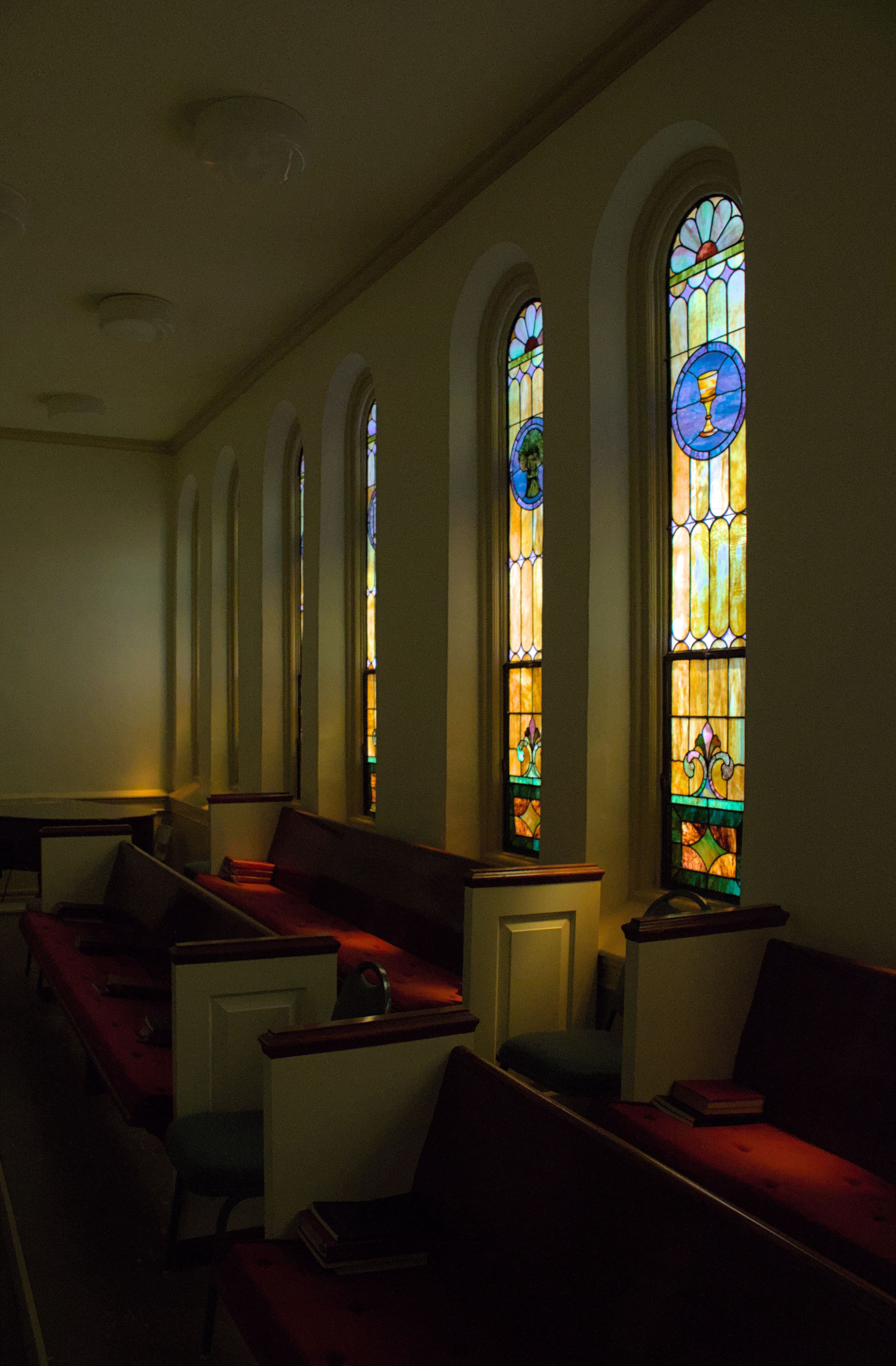 Church interior with stained glass windows and wooden pews offering a serene atmosphere.