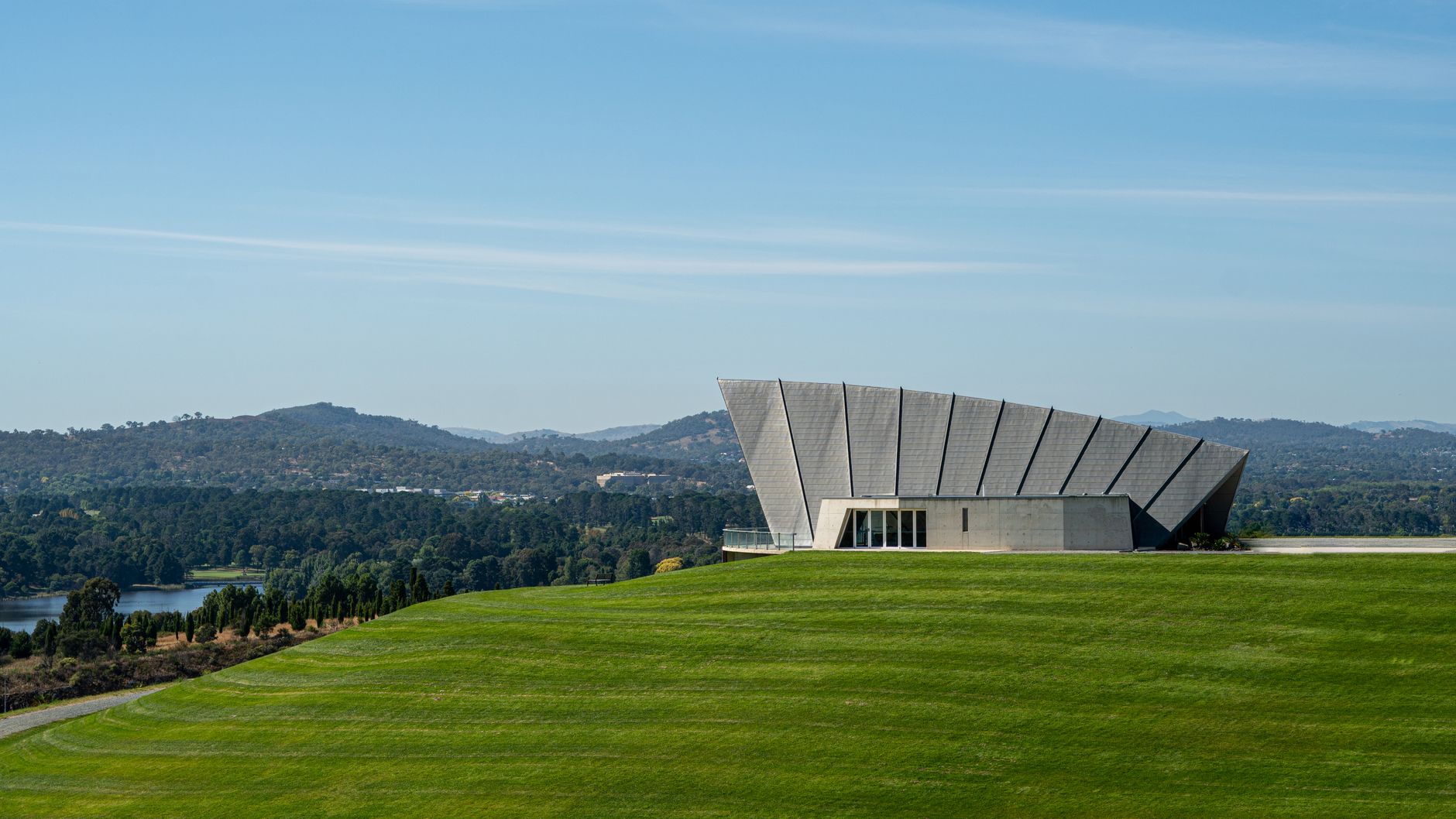 Scenic view of Margaret Whitlam Pavilion with hills and greenery in Canberra, Australia.