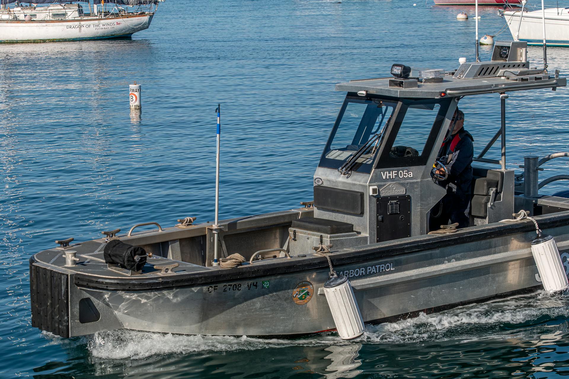 A harbor patrol boat cruising through calm blue waters, ensuring safety and security.