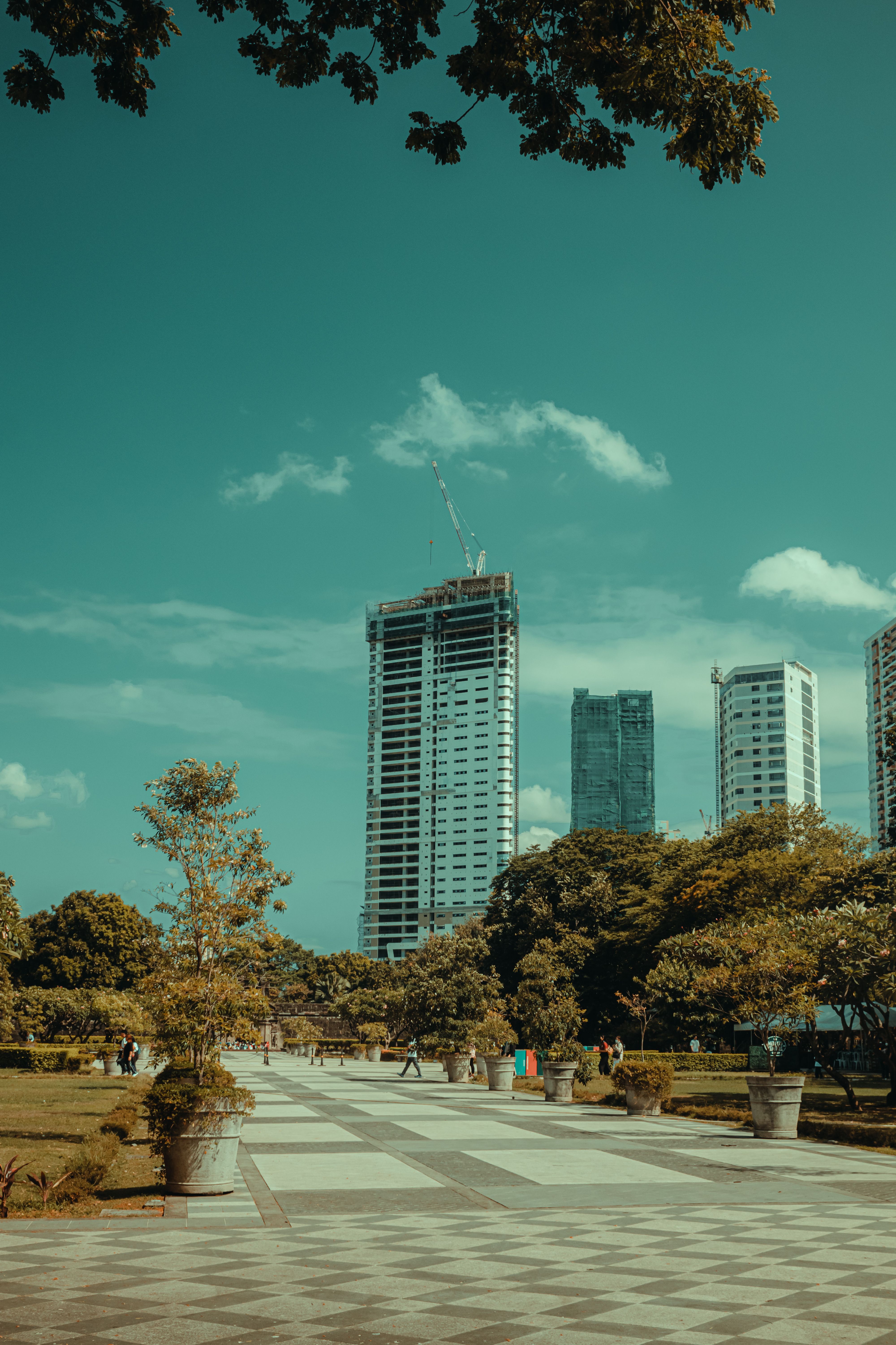 Pavement in a Park and Modern Skyscrapers under Blue Sky · Free Stock Photo